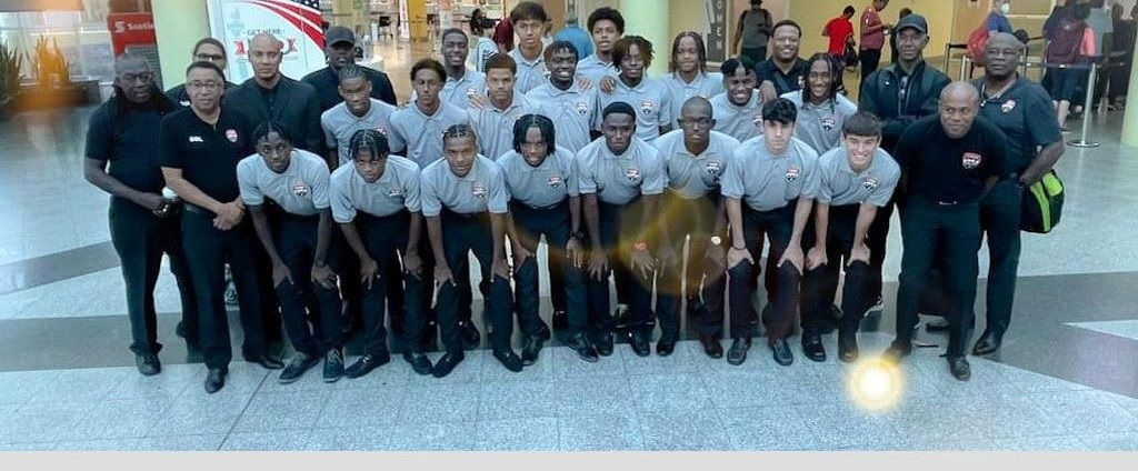 T&T Under-17 men's football team coach Shawn Cooper, second from left middle row, poses with players and fellow members of the technical staff at the Piarco International Airport heading out to Jamaica, yesterday morning. - Courtesy TTFA Media