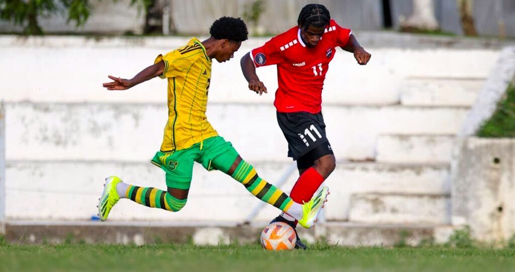 T&T’s Malachi Webb (R) goes past Jamaica’s Jahmani Bell during Under-20 Practice Match at the UTT O’meara on Thursday. 