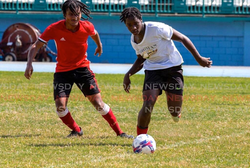 Scarborough Secondary student Keanu Boatswain, right, is defended by Mason Hall Secondary student Omar Daniel during national under-20 screening at the Dwight Yorke Stadium, Bacolet last Saturday. - David Reid