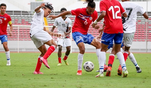 T&T players led by Josiah Wilson, left, challenges a player from Costa Rica for the ball during their warm-up match yesterday. ...Courtesy TTFA Media