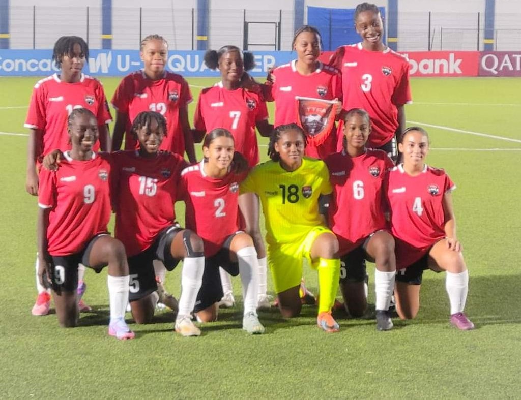 T&T Under 17 women's team with goalkeeper, Mikaela Yearwood, third from right, and her teammates before their match against the Cayman Islands on Monday which T&T won 4-0.