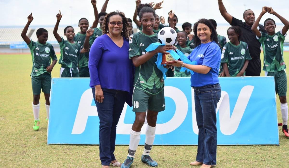 Flow senior marketing manager Ria Maharaj, front right, and TT Pro League CEO Julia Baptiste, front left, present W Connection Under-14 captain Molik Khan, centre, with the Flow Youth Pro League Cup U-14 trophy at Larry Gomes Stadium in Arima on Sunday