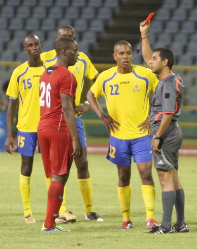 Referee Michael Ragoonath, right, issues red cards to Neal & Massy Caledonia AIA’s Devorn Jorsling, left, and Curtis Gonzales of Defence Force during the Lucozade Sport Goal Shield final at the Hasely Crawford Stadium, Mucurapo last month. Caledonia won 3-1. Photo: Anthonty Harris.