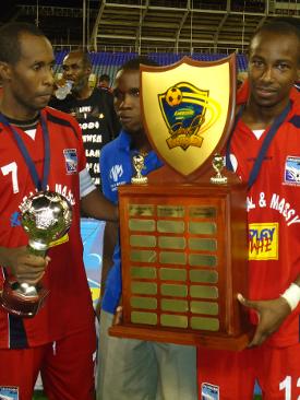 Photo: Caledonia AIA captain Stephan David (left) and Kareem Joseph hold the Lucozade Sport Goal Shield trophy and the CFU Club Championship title is next