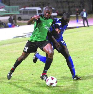 SHIELDING: San Juan Jabloteh's Glen Cyrano, left, shields the ball from St Ann's Rangers player Jevon Morris during their Lucozade Goal Shield quarter-final encounter at the Larry Gomes Stadium in Malabar on Friday Night. Jabloteh trounced their opponents 6-0. -Photo: CURTIS CHASE