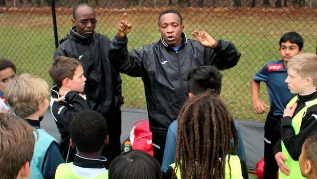 Coaches Bakela Nare, left, and Andre Fortune, right, lead practice for Inter Development Futbol at a field in MacGregor Village in Cary.