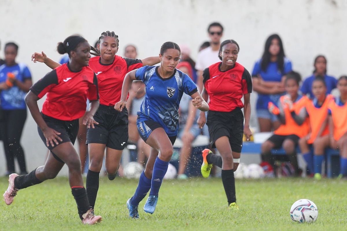 Holy Name Convent’s Calypso Ayoung runs through Bishop Anstey High defence during the Secondary Schools Football League Girls Championship match at Fatima Grounds in Port-of-Spain on Sunday October 16th 2022. Holy Name won 8-4. (Photo by Daniel Prentice)