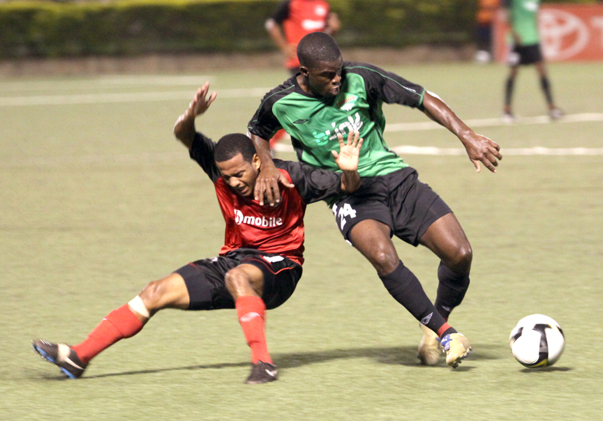 Public attacker Hayden Tinto is fouled by Jabloteh defender Glenton Wolfe before the Toyota Classic's opening goal. Photo: Kenroy Ambris.