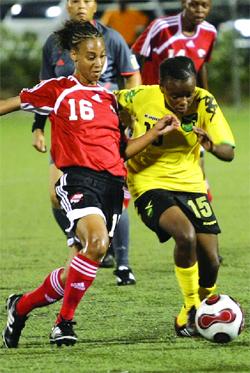 T&T’s Kareena Seaton is all out to withstand the challenge of Jamaica’s Trudy Carter during their CFU qualifier at the Marvin Lee Stadium last night. The game ended 1-1. Photo: Anthony Harris