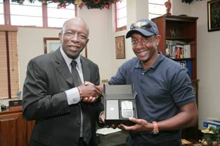 Photo shows Warner presenting Latapy with a bMobile Blackberry phone on Monday (Photo by - Shaun Fuentes))
