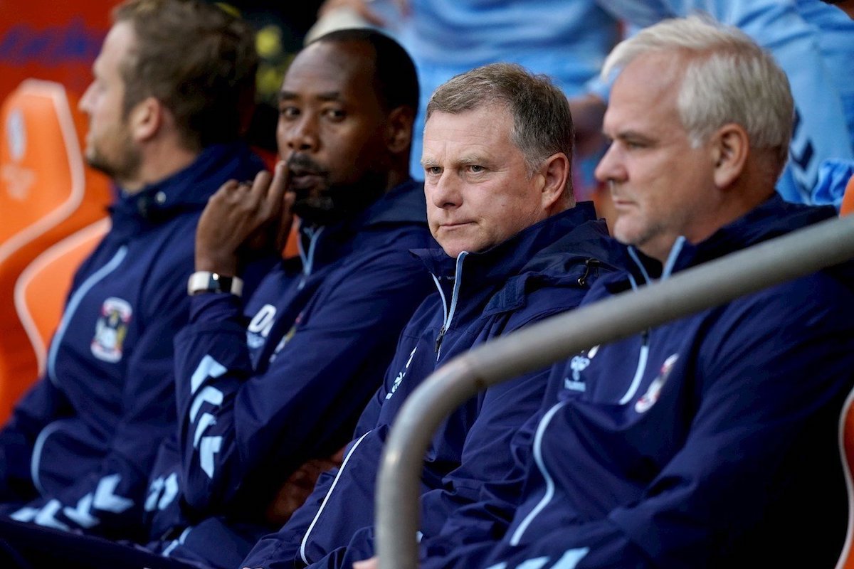 Coventry City coach Dennis Lawrence (second from left) in the dugout with Mark Robins, Adi Viveash and goalkeeping coach Aled Williams (far left) during a match against Blackpool at Bloomfield Road, Blackpool, England on August 17th 2021.