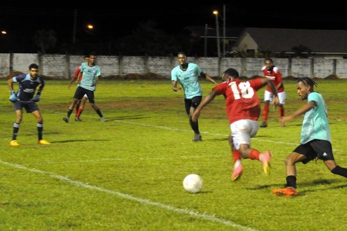 The goalkeeper keeps clos watch as Randy Hughes of Mayaro All Stars bursts past the Seed of Greatness Biche FC defenders during the launch of the bpTT-AMSF Mayaro Football League. - Courtesy CJ Communications