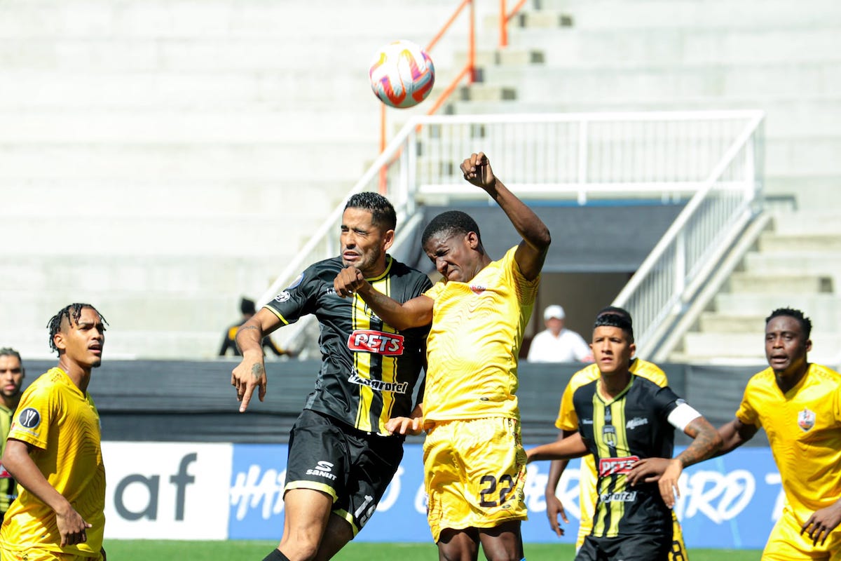 AC Port of Spain's Jameel Neptune (#22) contests a header while Michel Poon-Angeron (left) and Robert Primus (right) look on during a Concacaf Caribbean Cup match against Moca FC at Estadio Cibao, Santiago, Dominican Republic on Friday, August 25th 2023.
