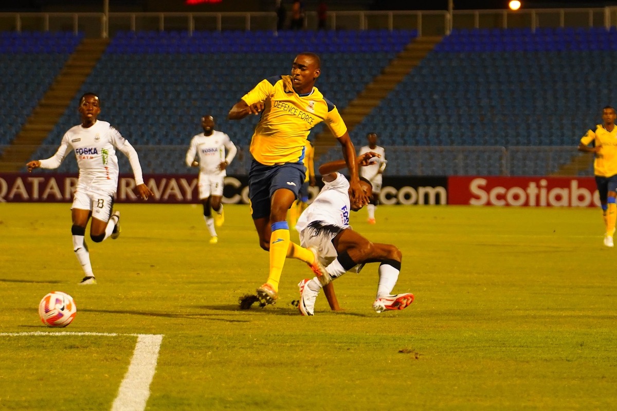 Defence Force's Reon Moore skips past the challenge of Adrian Reid on the way to scoring the opening goal against Cavalier FC at Hasely Crawford Stadium on Thursday, August 24th 2023.