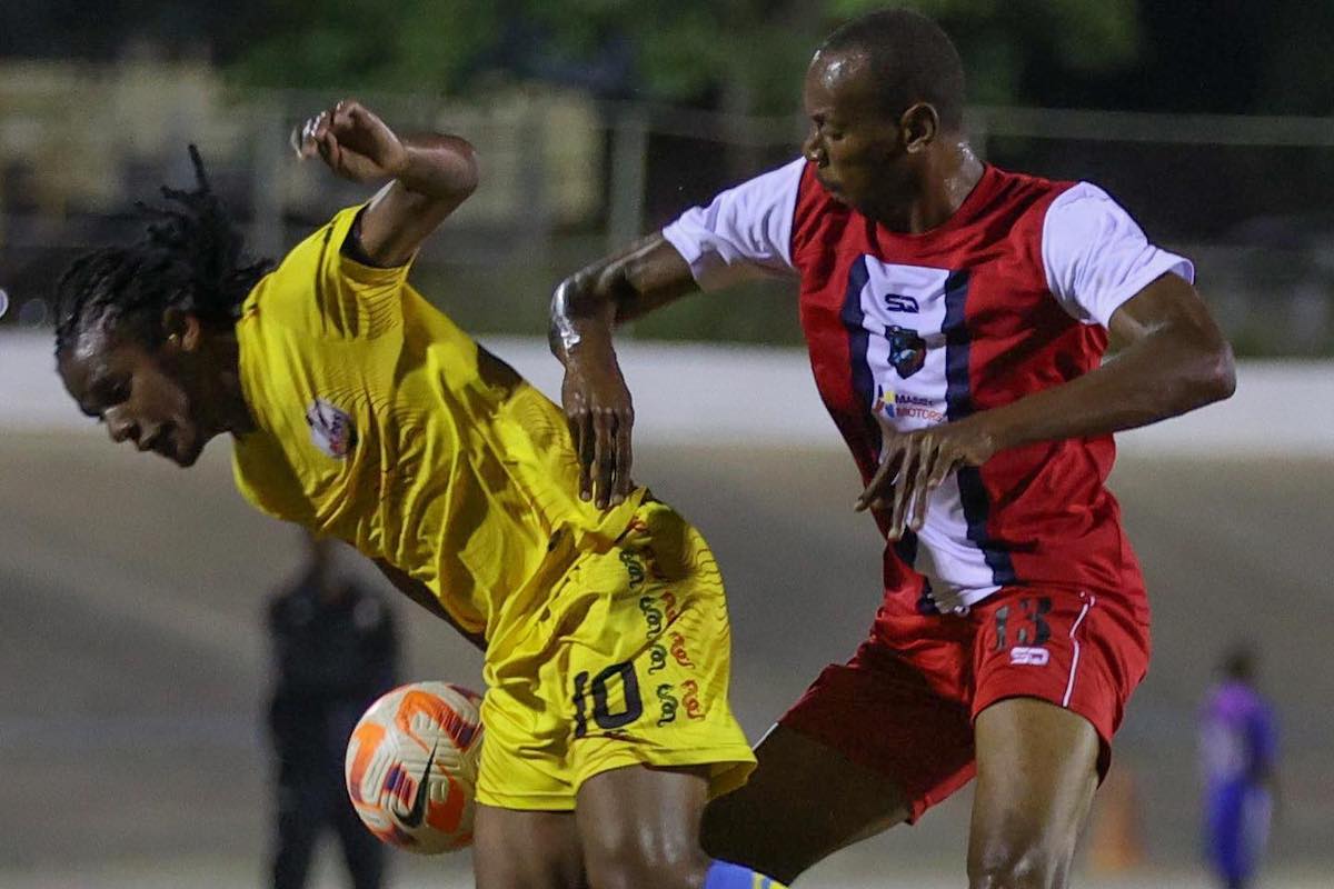 AC PoS captain Duane Muckette (L) and Caledonia forward Kevon Woodley (R) tussle for possession during their TTPFL game at the Arima Velodrome on Sunday, February 18th 2024.