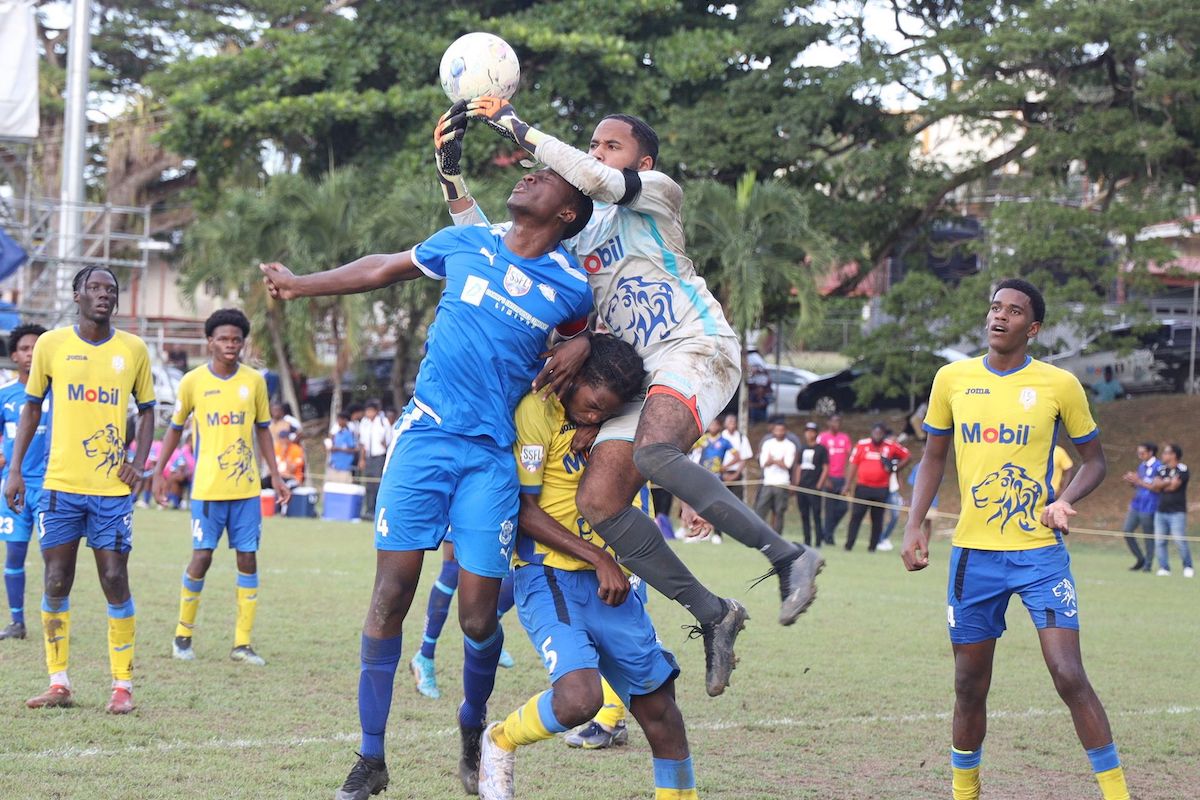 Presentation College San Fernando goalkeeper Kanye Lazarus leaps over his defender and Naparima College captain Jason Pascall, during a Secondary School Football League match at Naparima Grounds, Lewis Street, San Fernando, on October 19th 2023. PHOTO BY: Rishi Ragoonath