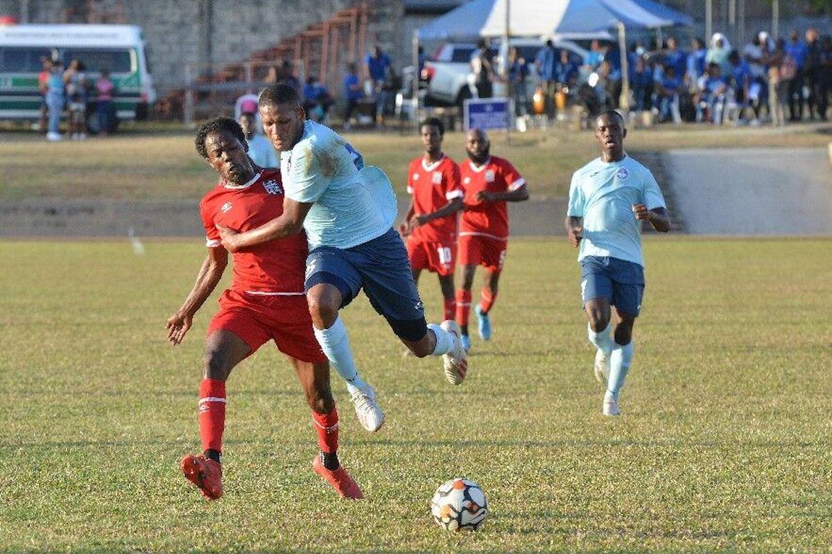 Police FC’s Christian Thomas, right, collides with Cunupia FC’s Kadeem Graham as they chase the ball during this match in the Ascension Tournament at the Police Barracks, St James on Sunday, April 10th 2022. Police won 2-1. Photo: ISHMAEL SALANDY
