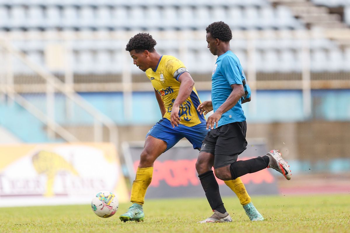Presentation College captain and striker Caleb Boyce, left, takes on Malick Secondary defender Malachi Woodley during the Secondary School Football League Premiership match at the Ato Boldon Stadium in Couva on September 17th 2022. Presentation won 3-1. Boyce will try to lead Presentation today against QRC from 3.30 pm. PHOTO: Daniel Prentice