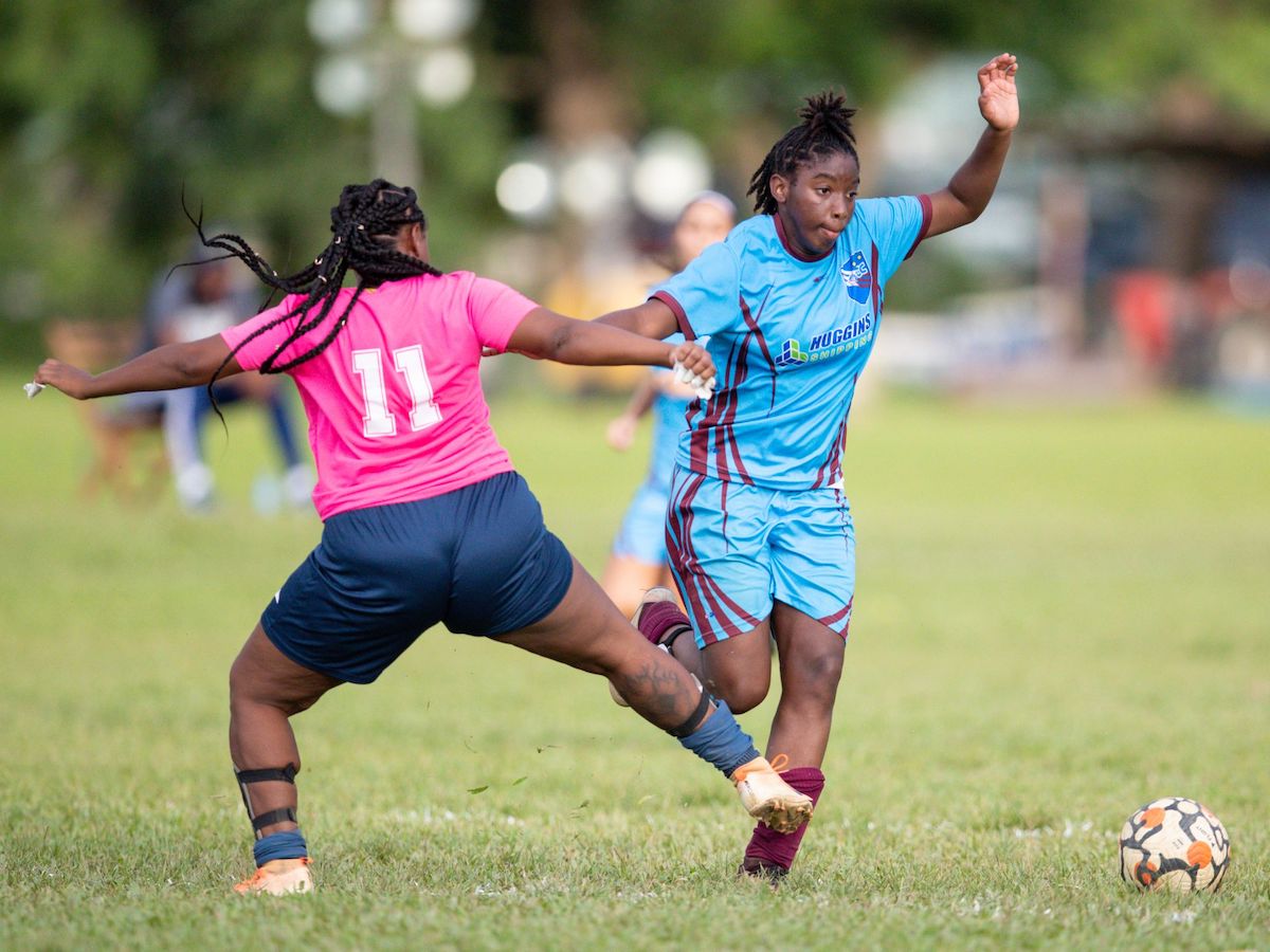 QPCC FC Women midfielder Orielle Martin, right, skips past the challenge from Sabrina Long of North Coast FC Women during the TT Wolf Ascension Tournament at CIC grounds on August 13th 2022 in Port-of-Spain. Martin scored three goals on the weekend in QPCC 17-0 win over Diego Martin Central. (Photo by Daniel Prentice)