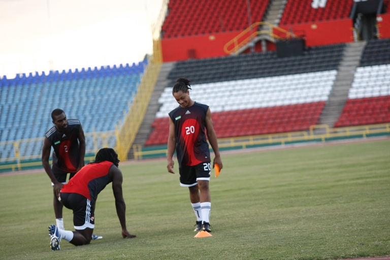 Kenwyne Jones speaking with Shahdon Winchester while training with senior team - Clyde Leon looks on.