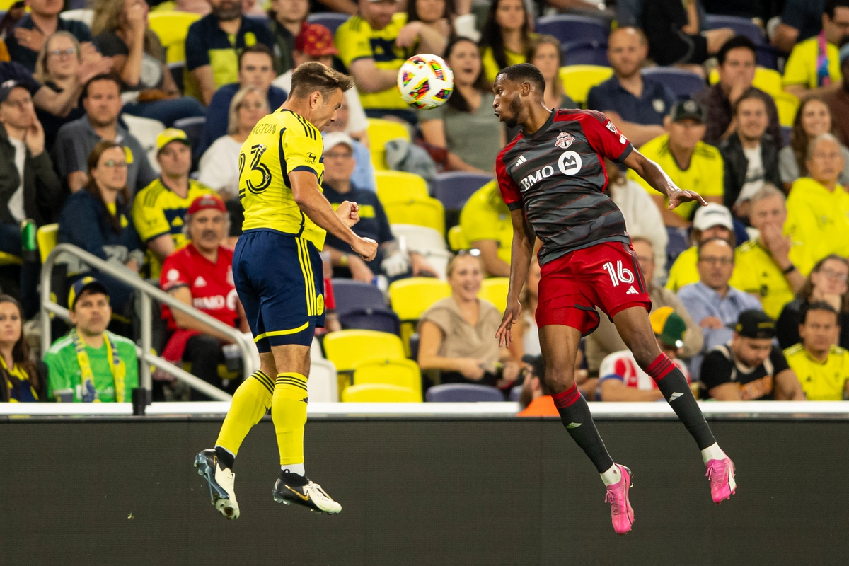 May 15, 2024; Nashville, Tennessee, USA; Toronto FC forward Tyrese Spicer (16) and Nashville SC defender Taylor Washington (23) heads the ball during the second half at Geodis Park. Mandatory Credit: Steve Roberts-USA TODAY Sports