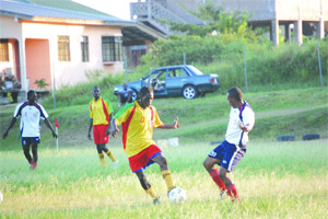 Tobago footballers playing on bushie field.