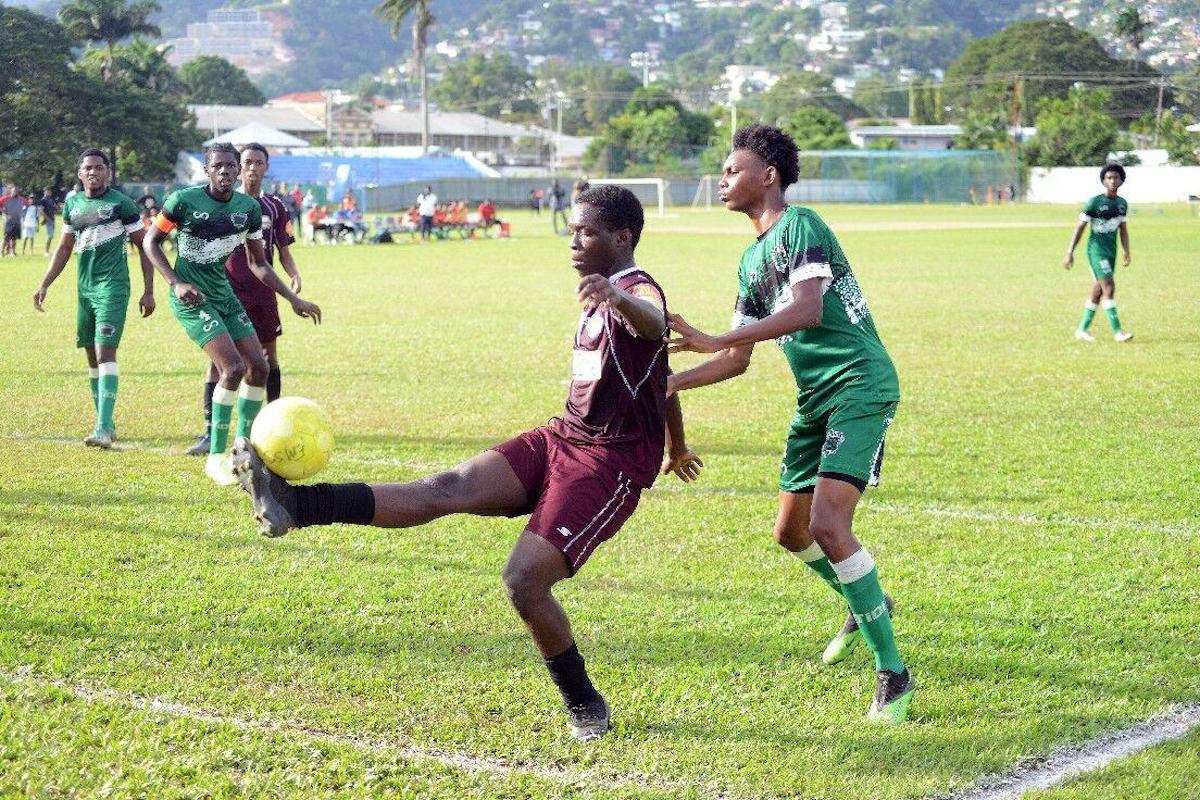 ‘I HAVE IT’: East Mucurapo Secondary’s Khidr Atiba controls the ball under pressure from St Augustine Secondary’s Giovanni Hospedales during their SSFL relegation playoff match at St Mary’s Ground, St Clair on Monday, December 12th 2022. –Photo: ISHMAEL SALANDY