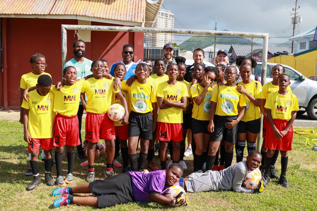 Members of the St Crispin's Anglican Primary School football team with technical staff of the US men's football team who made a donation of equipment at the school's compound on Ariapita Avenue in Woodbrook on Tuesday, November 21st 2023. PHOTO BY: Roneil Walcott