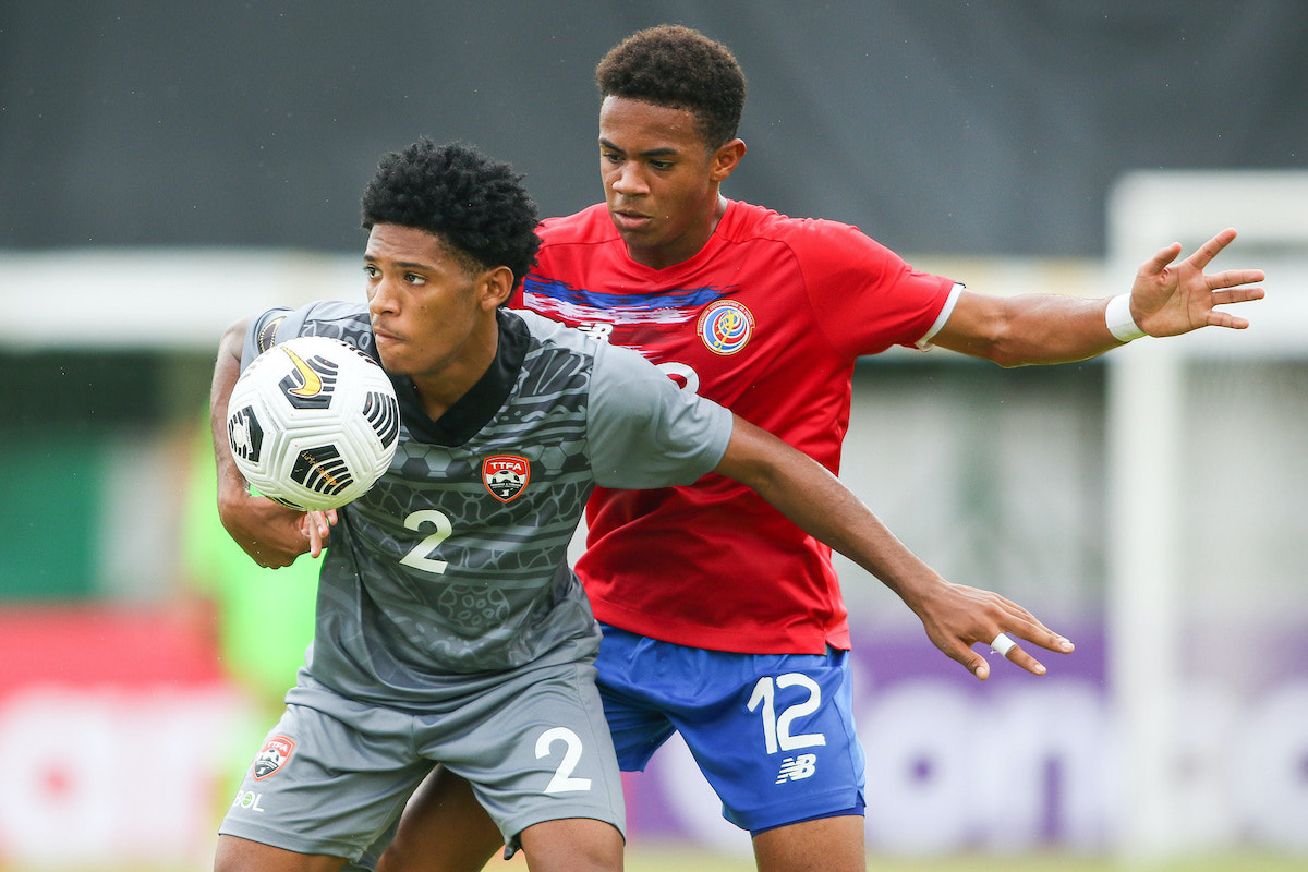 UNDER PRESSURE: Trinidad asnd Tobago right back Christian Bailey, left, is under pressure from Costa Rica striker Shawn Johnson as Costa Rica won the CONCACAF Men’s Under-20 Championship round of 16 match 4-1, yesterday, in San Pedro Sula, Honduras. —Photo courtesy CONCACAF
