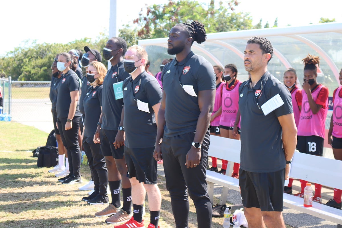 Trinidad and Tobago Women's Head Coach Kenwyne Jones and the rest of the technical staff sing the national anthem ahead of a Concacaf W Championship Qualifier against Turks and Caicos Islands at TCIFA National Academy on April 9th 2022.