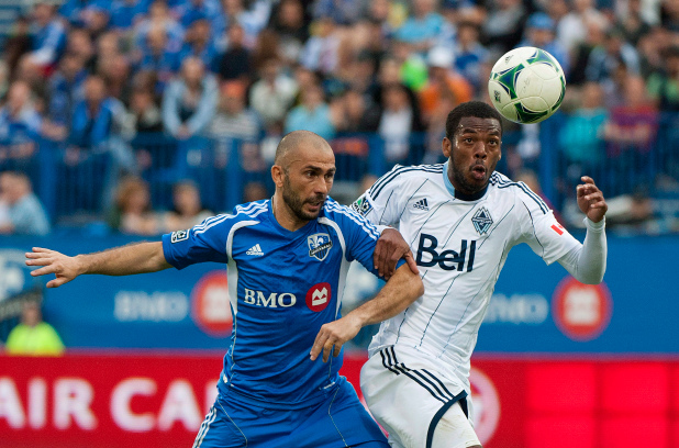 Vancouver Whitecaps centre back Carlyle Mitchell, right, battles for the ball against Montreal Impact's Marco Di Vaio, left, during an MLS regular season game on Sept. 21. 2013