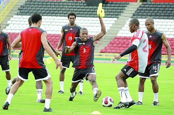 Kern Cupid number three and Glenroy Samuel go for the ball, while team-mates Carlos Edwards, Under-20 forward Juma Clarence # 19 and Julius James # 16 look on during the Soca Warriors practice session at the Hasely Crawford Stadium. Photo: Anthony Harris