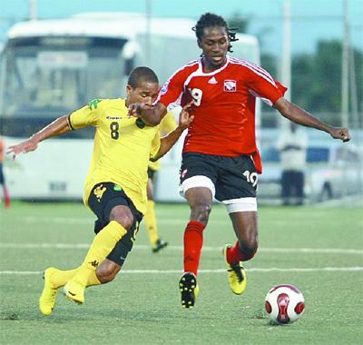 Jamaica’s defender Eric Verna, left, attempts a sliding challenge on T&T’s Keon Daniel during yesterday’s friendly match at the Marvin Lee Stadium, Macoya. Jamaica won 3-1. Photo: ANTHONY HARRIS