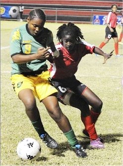 Jamaica's Shantell Thompson (left) battling with Trinidad and Tobago's Khadisha Debesette during yesterday's final match in the Under-17 Women's Caribbean Football Union World Cup qualifiers at the Anthony Spaulding Sports Complex in St Andrew. (Photo Credit: Jamaica Gleaner).