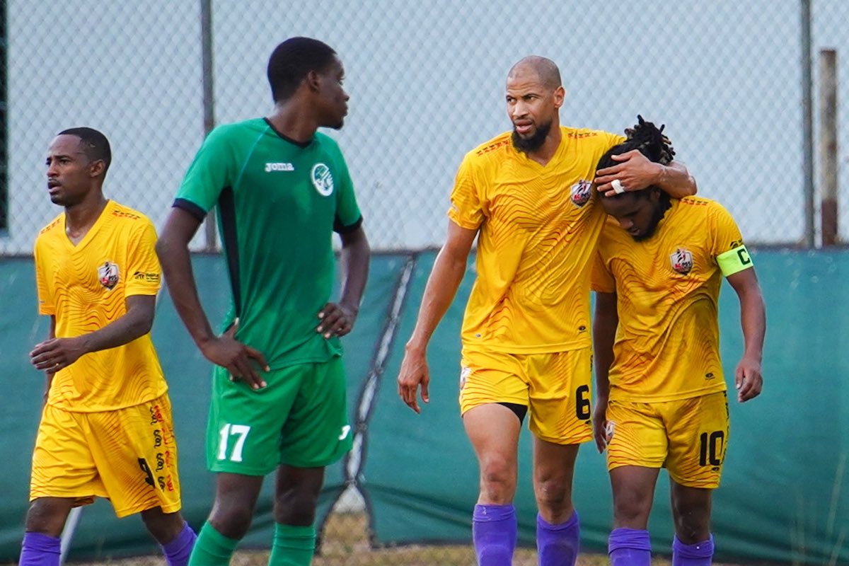 AC Port of Spains' Radanfah Abu Bakr embraces goalscorer Duane Muckette during a game against W-Connection at La Horquetta Recreation Ground on Saturday, April 22nd 2023